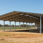 Australian horse infrastructure showing large galvanized steel stable complex with engineered roofing system for commercial equine operations.