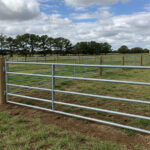 Durable livestock equipment galvanized steel gate with timber posts showing quality Australian farm fencing system built for reliable paddock and livestock management.