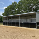 Commercial horse property blueprint multi-stable complex featuring galvanized steel construction with black panel system for professional equine operations.