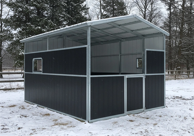 A prefabricated stable kit with galvanized steel framing and black HDPE panels installed in a snowy environment for the Australian and New Zealand equine industry. This durable portable horse stable offers a secure and versatile solution for professional horse stables.